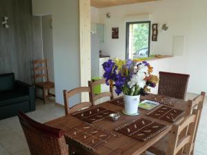 a dining room table with a vase of flowers on it at Modern Chalet in Roquetaillade with Swimming Pool in Roquetaillade