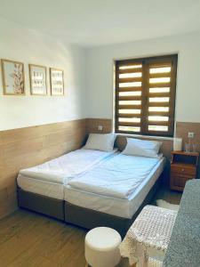 a bedroom with a large bed with a window at Къща за гости Василеви in Bratsigovo