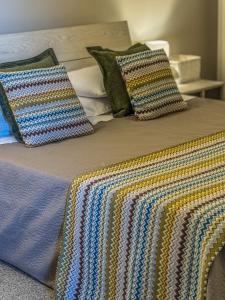 a bed with pillows and a blanket on it at Casa del Lauro - Apartment in Locorotondo