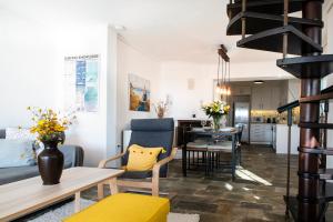 a living room and dining room with a table and chairs at Panoramic Seaview Maisonette with Garden in Saronida