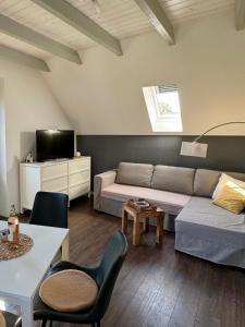 un salon avec un canapé et une table dans l'établissement Ferienwohnung Landart, à Hilter 15 autres photos