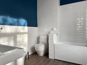 a white bathroom with a toilet and a bath tub at Odeska Astoria in Odesa