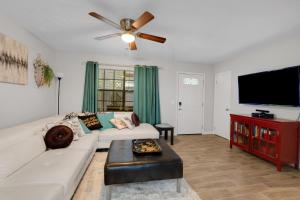 un soggiorno con un divano bianco e una TV a schermo piatto di Family-Friendly 3BR Oasis in Powder Springs home a Powder Springs