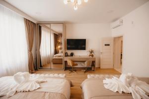 a hotel room with two beds and a desk at Eden Central Boutique Suites - Garden & Spacious Apartments in Cluj-Napoca