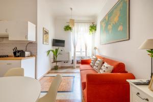 a living room with a red couch and a kitchen at Maurice's Apt, hidden gem in Rome for food lovers in Rome