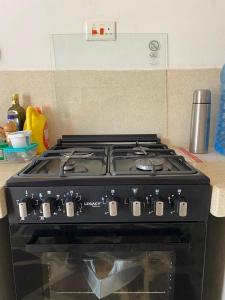 a black stove top oven sitting in a kitchen at Red Land House in Watamu +18 photos