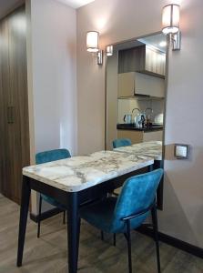 a dining room with a table and blue chairs at Luxury Hotel Suite Apartment in Batumi +25 photos