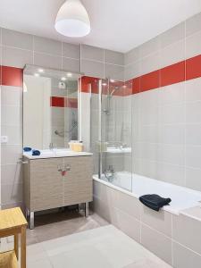 a bathroom with a tub and a sink and a mirror at Le 56, 2 chambres, terrasse, Voiron in Voiron +26 photos