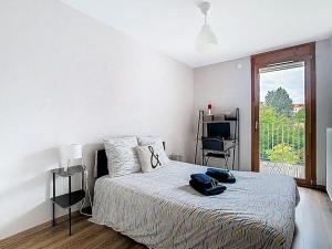 a bedroom with a bed with two bags on it at Le 56, 2 chambres, terrasse, Voiron in Voiron
