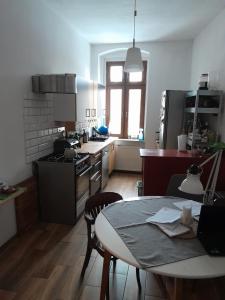 a kitchen with a table and a kitchen with a stove and a table at Yoda house in Legnica