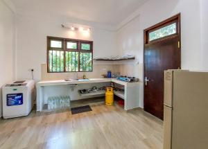 a kitchen with a sink and a refrigerator at White Villa Goyambokka in Tangalle +123 photos