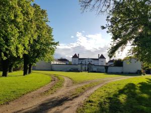 a dirt road in front of a white house at Chateau des Perichons in Poncins