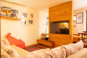 a living room with a couch and a flat screen tv at Maison Villair - Courmayeur in Courmayeur