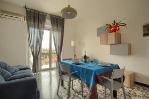 a dining room with a blue table and chairs at appartamento di fronte alla pista ciclabile con 2 camere da letto e wifi in Imperia