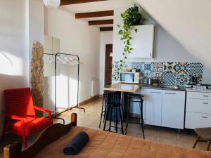 a kitchen with white cabinets and a table and chairs at Repülőhal Apartmanház in Zebegény
