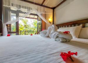 Un dormitorio con una cama con sábanas blancas y una ventana. en White Villa Goyambokka, en Tangalle