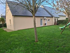 a house with a tree in a yard at Le petit coin de Paradis classé 3 étoiles in Hermanville-sur-Mer