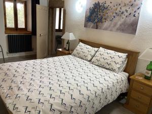 een slaapkamer met een bed met een wit en zwart dekbed bij Mas de la Giralde - Bed and Breakfast in Payzac +23 foto's