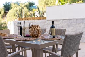 Una mesa con botellas de vino y una cesta encima. en Crystal House 2, en Neos Marmaras