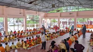 NaimishāranyaVagishanand Swami Hariharanand Ashram的一群人坐在一个大房间里