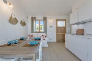 une cuisine et une salle à manger avec une table en bois et des plaques bleues dans l'établissement Casa dell'Alba Dorata, à Tertenìa