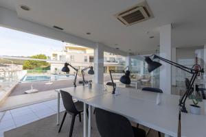 a white room with a table and chairs and a balcony at Cliffs Apartment - Astonishing view over Sesimbra bay by Trip2Portugal in Sesimbra