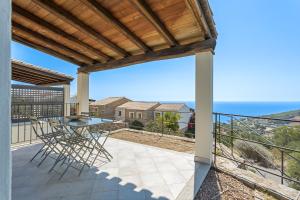 un patio avec une table et des chaises sur un balcon dans l'établissement Casa dell'Alba Dorata, à Tertenìa