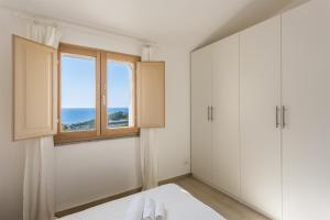 une pièce blanche avec une fenêtre et une table dans l'établissement Casa dell'Alba Dorata, à Tertenìa 16 autres photos