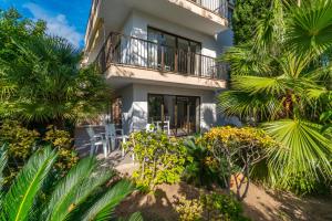 un bâtiment avec des chaises et des arbres devant dans l'établissement Ponent Cala Ratjada Apartments F, à Cala Ratjada