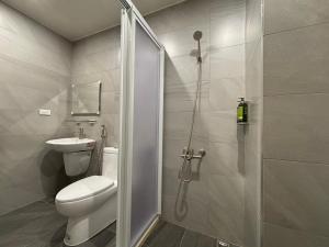 un bagno con doccia, WC e lavandino di Okura Hotel a Città di Pingtung
