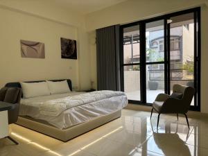una camera da letto con un letto, una sedia e una finestra di Okura Hotel a Città di Pingtung