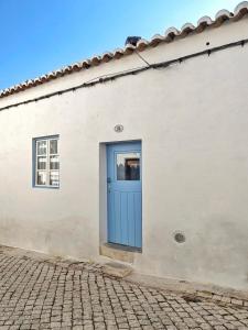 a white building with a blue door at Casa Caiada in Beja +13 photos