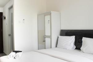 a bedroom with a bed with two slippers on it at Fancy and Nice Studio Apartment at Sayana Bekasi By Travelio in Bekasi