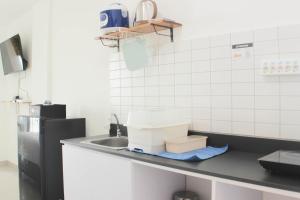 a kitchen counter with a sink and a box on it at Fancy and Nice Studio Apartment at Sayana Bekasi By Travelio in Bekasi