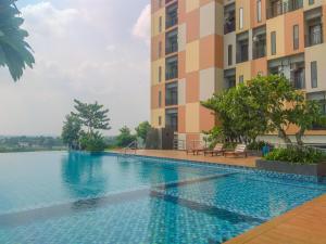 a swimming pool in front of a building at Fancy and Nice Studio Apartment at Sayana Bekasi By Travelio in Bekasi