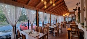 a restaurant with tables and chairs and a window at Del Monte Predeal in Predeal