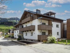 a white building with wooden balconies on a street at Haus Prem in Hopfgarten im Brixental