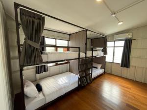 曼谷Green Cabin Hostel的铺有木地板的客房内设有三张双层床。