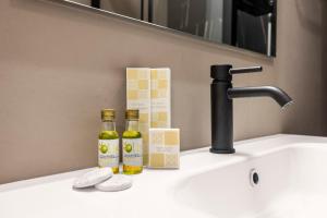 two bottles of oils sitting on a bathroom sink at Al Borghetto marinaro in Palermo