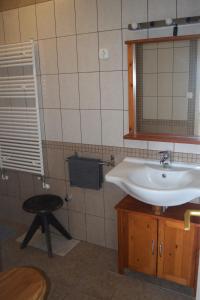 a bathroom with a sink and a mirror and a stool at Repülőhal Apartmanház in Zebegény +72 photos