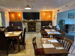 a restaurant with tables and chairs and a fireplace at Welbury Studio Sleeps 2 Pet Friendly & Parking in Northallerton