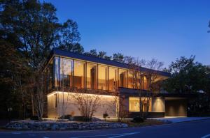 a house with glass windows on the side of a street at JADE D Plus and E Plus Hakuba in Hakuba