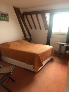 ウィッサンにあるMaison de charme à Wissantのベッドと椅子と窓のある寝室