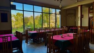 a dining room with tables and chairs and a large window at Rock City Resort in Swat