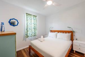 Un dormitorio con una cama blanca y una ventana. en Little Banksia 1 - LJHooker Yamba, en Yamba 25 fotos más