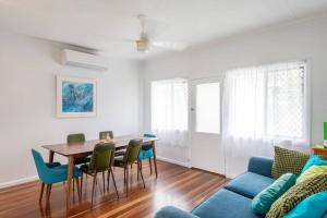 Una sala de estar con una mesa y sillas y un sofá. en Little Banksia 1 - LJHooker Yamba, en Yamba