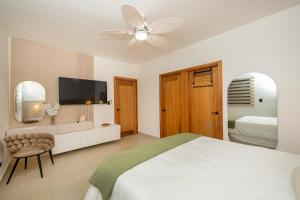 a white bedroom with a bed and a ceiling fan at Pool & Gym - 10min Aeropuerto y HOMS - Dream Stay in Santiago de los Caballeros +89 photos