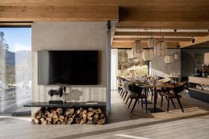 a dining room with a television and a dining table with chairs at Villa La Roca Garden & Spa ADULTS ONLY in Kościelisko