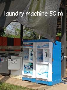 a blue and white refrigerator with a sign that reads laundry machine at Stay in art studio guesthouse in Kampong Huaibū