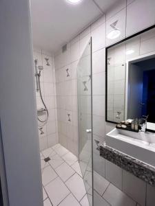 ein weißes Badezimmer mit Dusche und Waschbecken in der Unterkunft La Maison des Trois Arbres in Malmedy